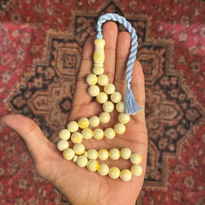 مسباح تراب الكهرمان – عاجي مُعرّق، شرابة زرقاء فاتحة