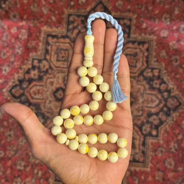 مسباح تراب الكهرمان – عاجي مُعرّق، شرابة زرقاء فاتحة